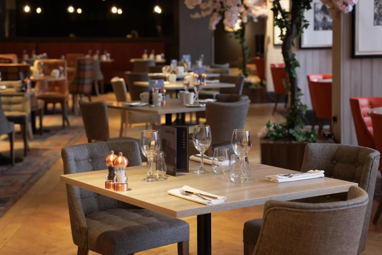 Restaurant tables and chairs set with wine glasses near Cambridge Street